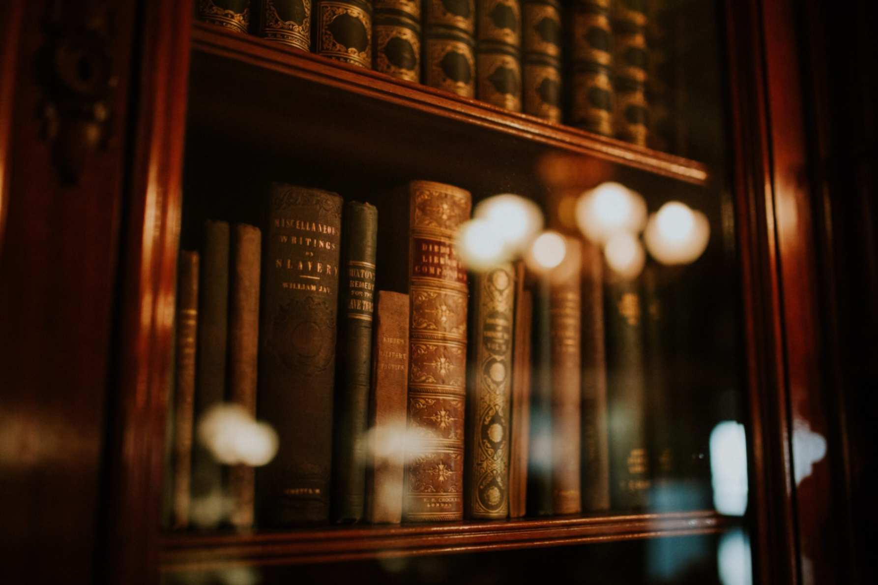 A set of books inside a glass cabinet