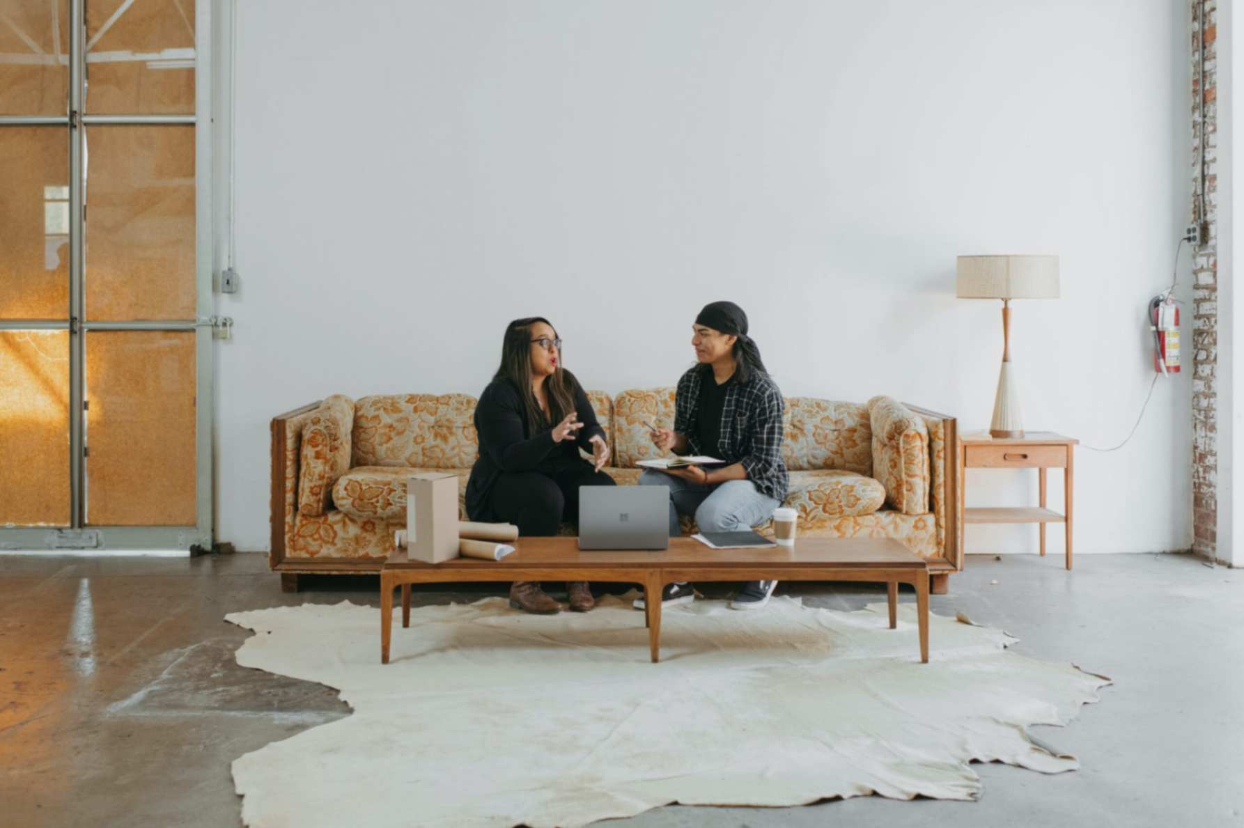 2 people sitting on a couch having a discussion