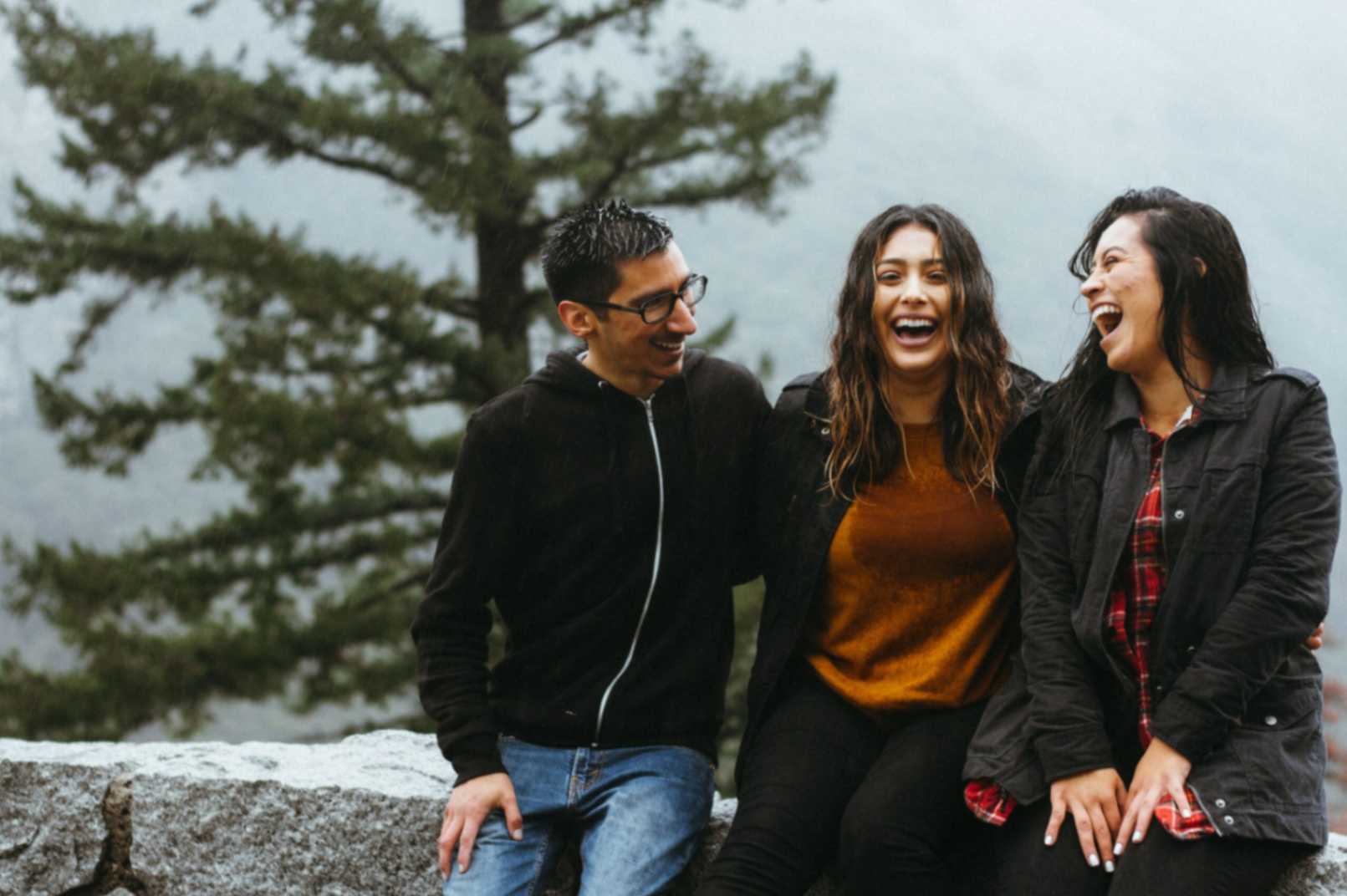 3 people sitting next to each other laughing