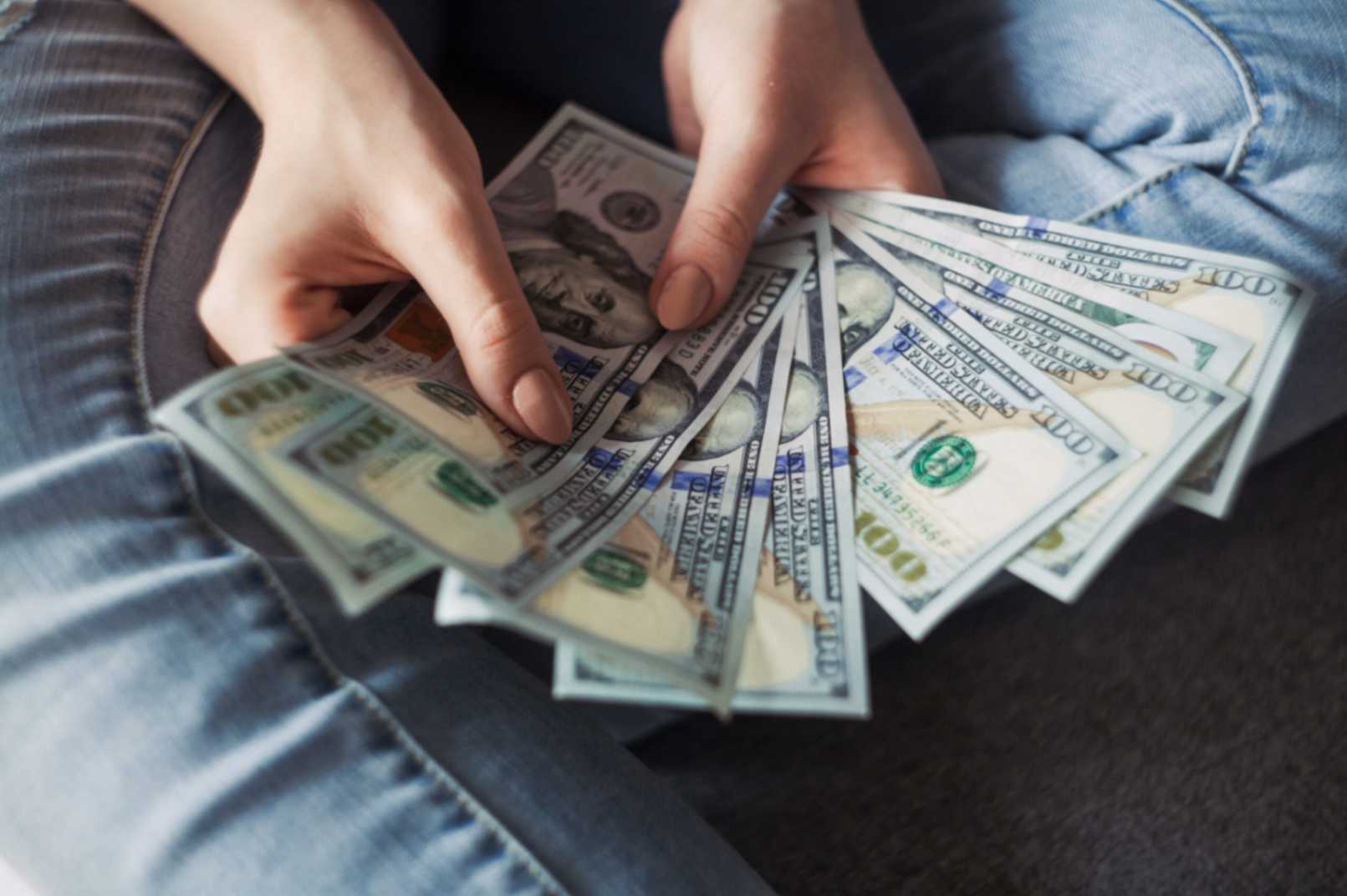 A person fanning out several 100-dollar bills